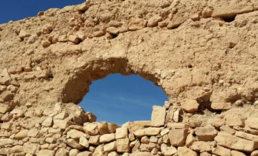 view of blue sky through hole in hand-stacked wall at Ait Ben Haddou