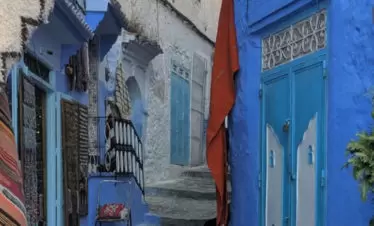 Blue-painted buildings lining a curving street in Chefchaouen (Blue City) - gallery image for 8 day Morocco itinerary from Tangier to Marrakesh -Mountains, Medinas & Nomad Tents