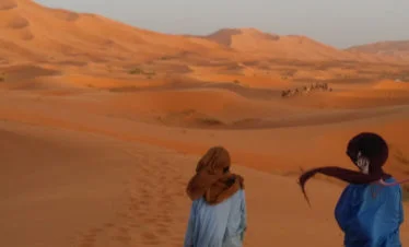 camelmen leading camels into windy big dunes - gallery image for 7 day Morocco Tour from Rabat to Marrakesh - Historic Sites, Saharan Sights - 1 week Morocco itinerary