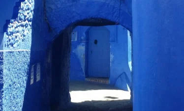 blue door as seen through blue arched passage - Chefchaouen