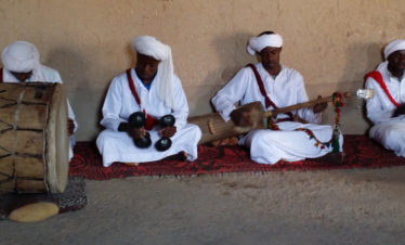 seated Gnawa musicians playing various instruments - Khamlia