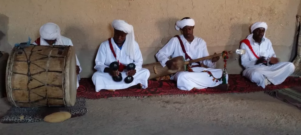 seated Gnawa musicians playing various instruments - Khamlia