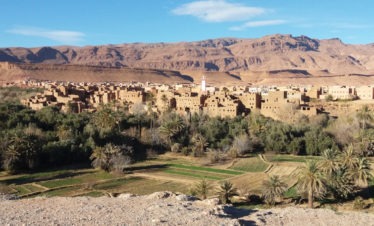 panoramic view of town of Tinghir, palm trees, mud-brick village, mountains in background