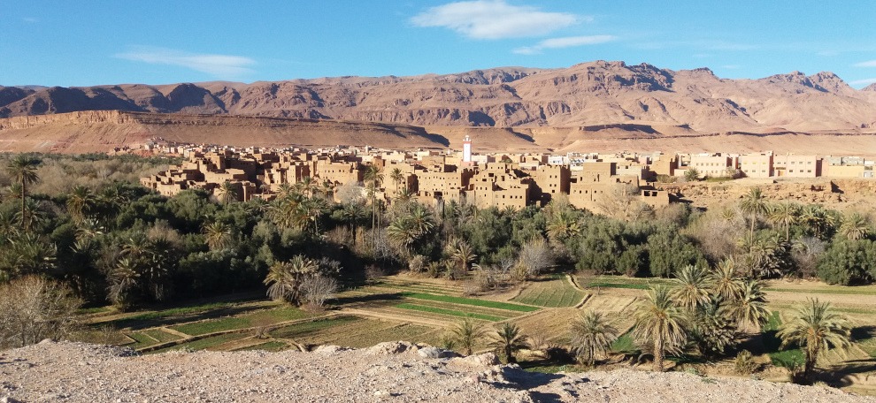 panoramic view of town of Tinghir, palm trees, mud-brick village, mountains in background