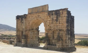 Roman ruins of large arched gate at Volubilis -gallery image for 8 day Morocco itinerary from Tangier to Marrakesh - Mountains, Medinas & Nomad Tents