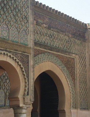 detail of historic Bab Mansour gate in Meknes, showing intricate carved stone and zelig tilework