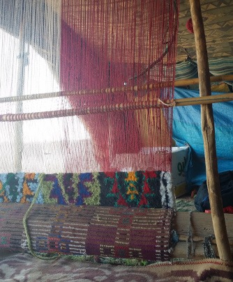 handmade Berber loom with partially finished carpet in tent home of local desert nomad family