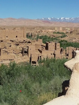 Kalaat M'Gouna (Valley of the Roses) - view over green valley with kasbah in the middle, snow-covered Atlas Mountains in the distance