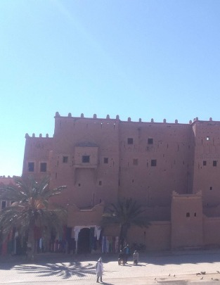 Ouarzazate - view of front facade of Kasbah Taourirt against blue morning sky