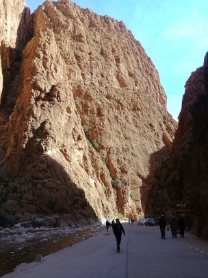 Todra Gorge-view of deep narrow rocky gorge in bright sunlight & shadow against bright blue sky