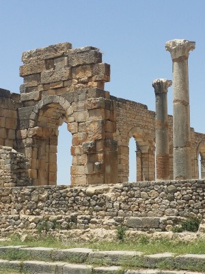 Volubilis-ruins of walls, arches & pillars against bright blue sky